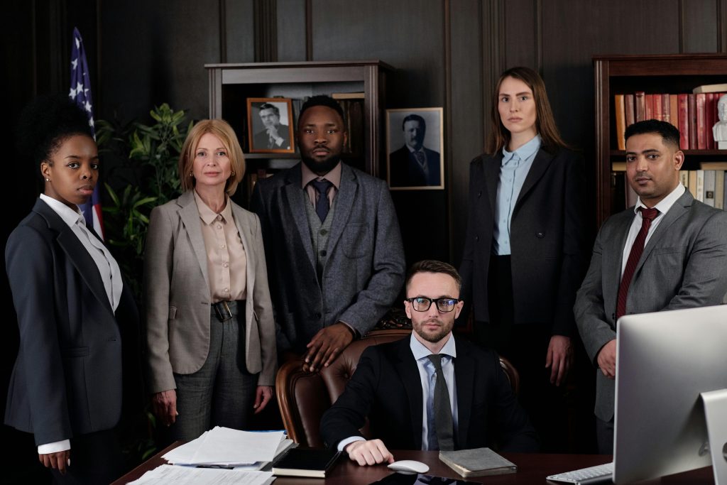 pexels-photo-4427431-4427431 A diverse group of business professionals posing in an office, showcasing teamwork and leadership.